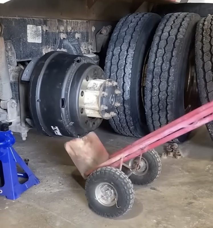 Dual rear tires on a semi truck jacked up for brake and axle service